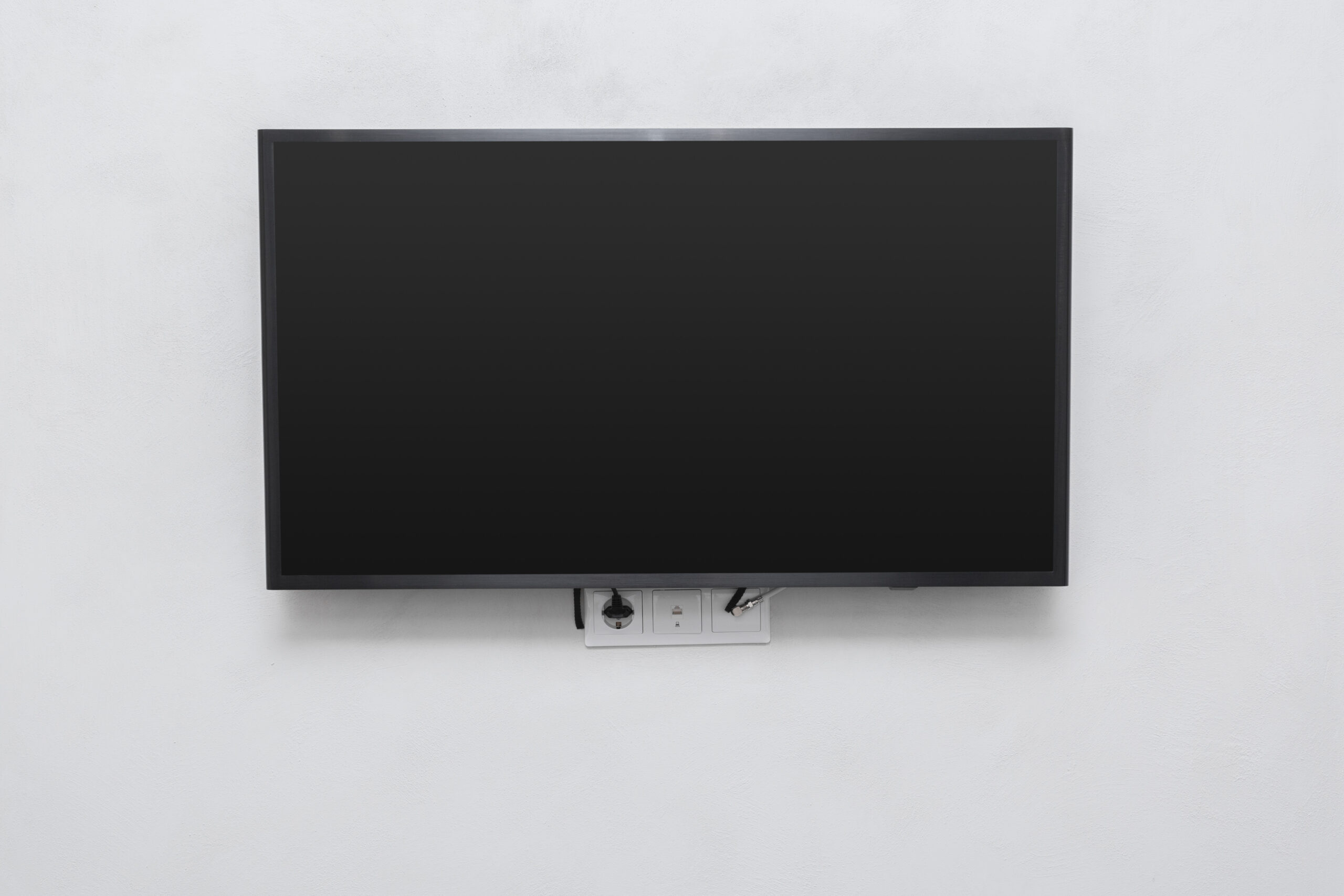 Professional TV mounting service in Kelowna by Mervin Audio Visual – wall-mounted flat screen TV with concealed cables and expert installation.